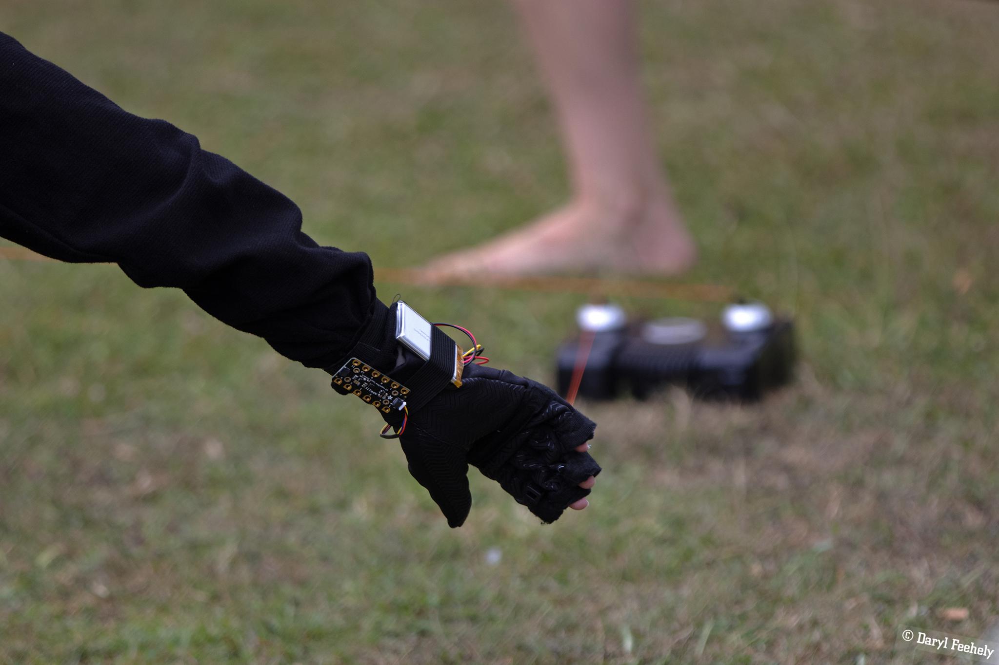 arm wearing electronic glove, gametrak and foot on grass
