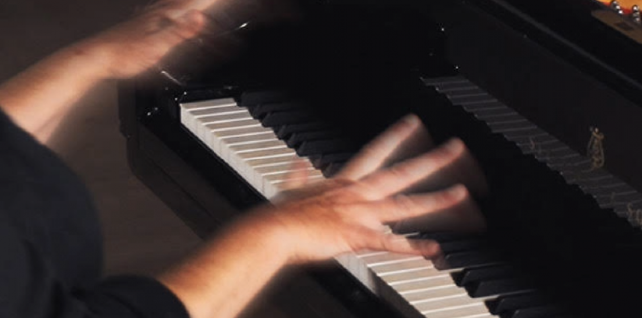 photo of piano keyboard with two hands held above the keys